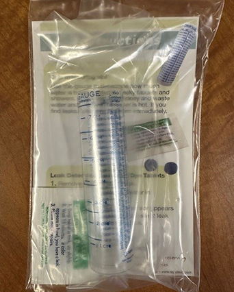 Leak detecting drip kit in a plastic bag with a plastic vial, dye tablets, and an instruction card